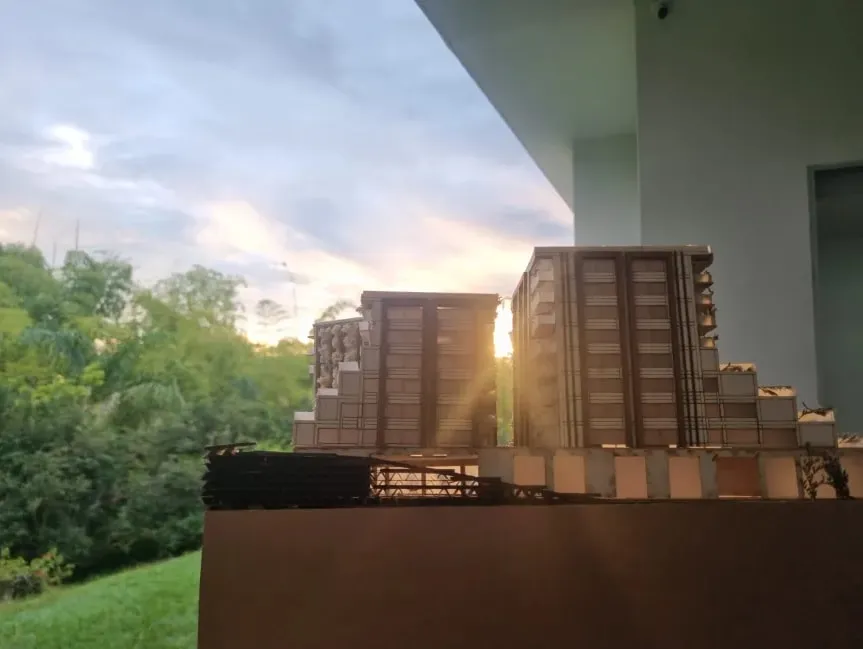 Maqueta a contraluz al atardecer, con el escalonamiento de las torres recortado contra el cielo.