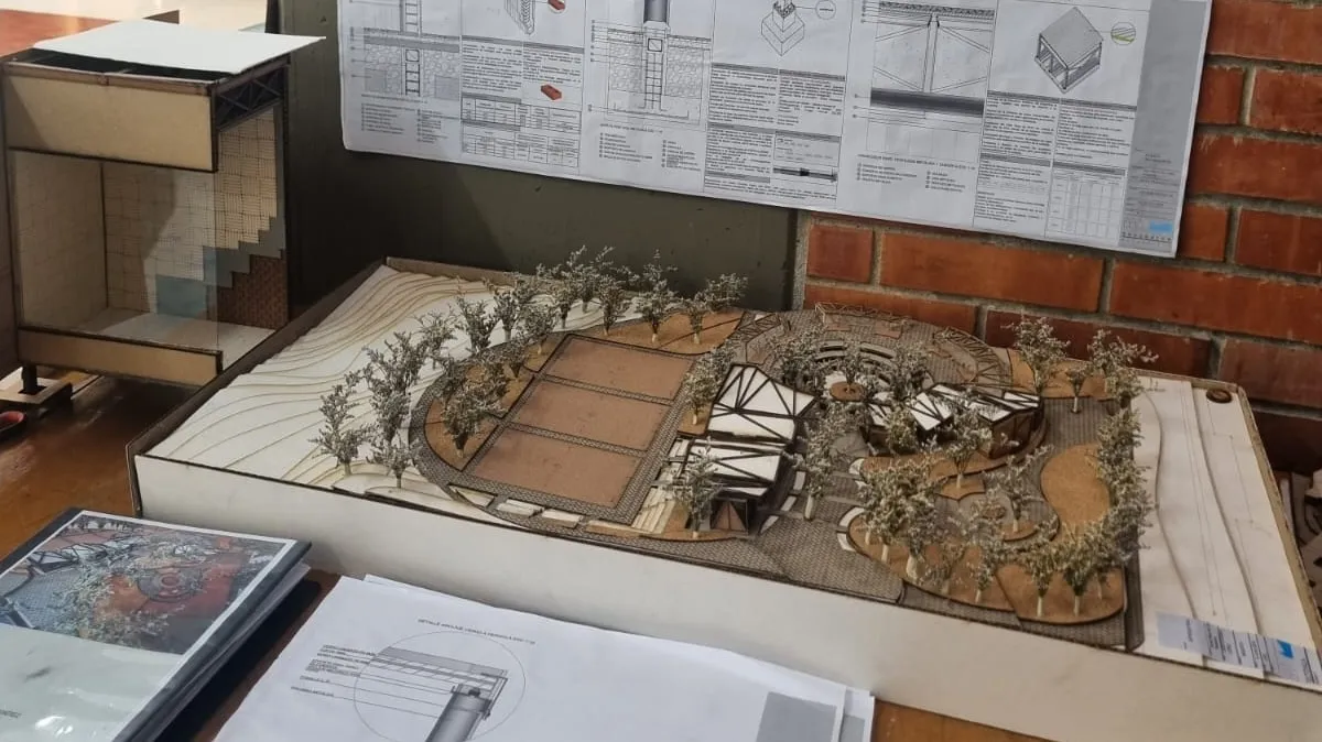 Maqueta de la UVA durante la entrega, acompañada de las fichas técnicas de detalle constructivo.