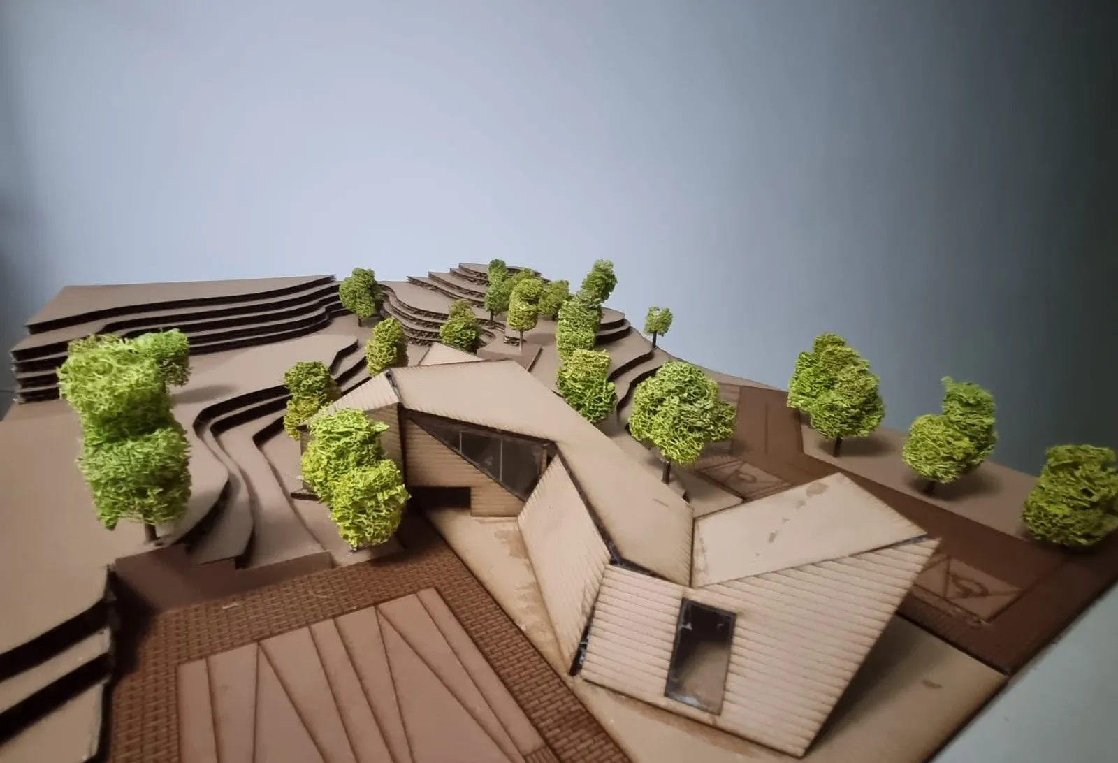 Maqueta del parador restaurante implantado sobre una ladera, con cubiertas inclinadas.